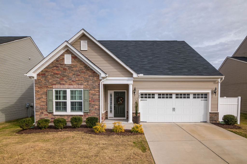 Outside of a suburban one story home with garage and driveway