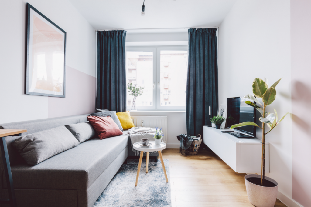 A modern, cozy condo living room with a large window, couch and home entertainment