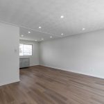 After image of a newly renovated modern living room with new flooring and pot lights