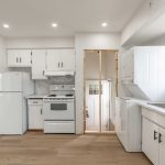 After image of a newly renovated sleek and modern kitchen with new appliances, flooring, and lighting